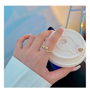 Detail of gold bow ring with sparkling diamonds worn on finger for a stylish feminine look