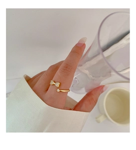 Close-up of golden bow ring with sparkling cubic zirconia on model finger