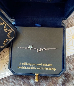 Détail d'un bracelet chat en argent avec pierre bleue dans un coffret cadeau bleu