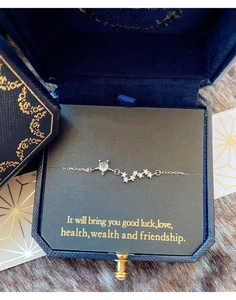 Détail d'un bracelet chat en argent 925 avec pierre verte dans son coffret bleu