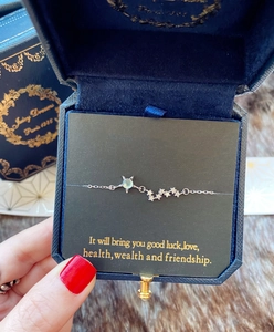 Gros plan sur un bracelet étoile en argent avec pierre bleu clair en coffret velours
