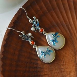 Detail of Hetian jade drop earrings with blue enamel floral patterns and red bead accents