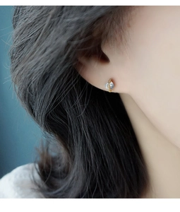Gros plan d'une boucle d'oreille planète minimaliste avec oxydes de zirconium sur modèle