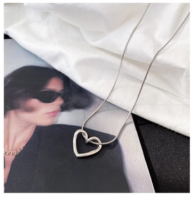 Detail shot of hollow heart pendant with S925 hallmark on a silver snake chain