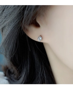 Macro d'une boucle d'oreille planète avec pierre centrale et halo brillant de petits diamants