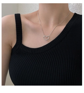 Minimalist silver hollow heart pendant necklace worn by model on a thin chain