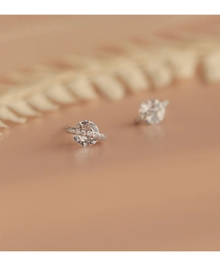 Vue macro de boucles d'oreilles planète en argent avec zircon et détails pavés