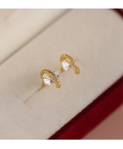 Gros plan de boucles d'oreilles planète dorées avec micro-cristaux et cristal de diamant