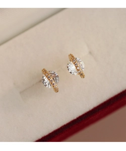 Détail macro de boucles d'oreilles planète dorées avec grande pierre et accents pavés