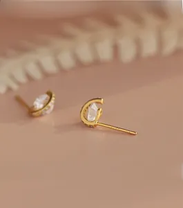 Gros plan du poinçon S925 sur le clou d'oreille planète doré en zircon en forme de C