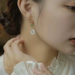 Orecchini pendenti in giada con perle verdi e pendenti ad anello bianco su una modella