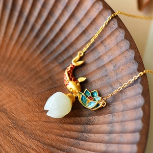 Detailed close-up of goldfish pendant with red enamel and white jade flower drop necklace
