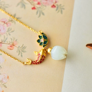 Detail of Chinese style koi fish pendant with green enamel flower and white jade lotus bud