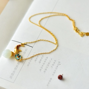 Macro detail of Chinese koi fish necklace with white lotus bead and gold chain