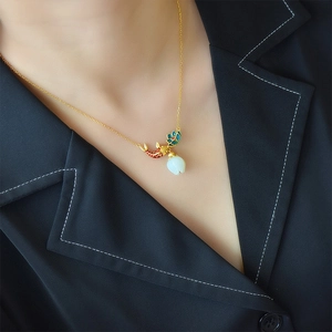 Ancient gold koi necklace with white jade flower pendant shown on female model