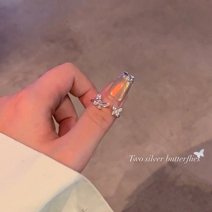 Close-up of silver butterfly open ring with sparkling zircon stones on finger