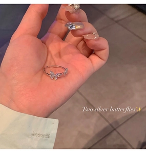Detailed view of silver open butterfly ring with sparkling zircon inlays on palm