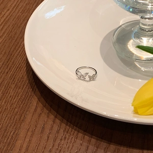 Close-up of double butterfly open ring with marquise and pave zircons on a ceramic plate