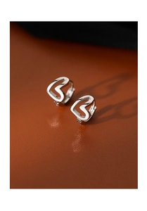 Close-up of elegant hollow heart-shaped silver earrings on a premium leather surface