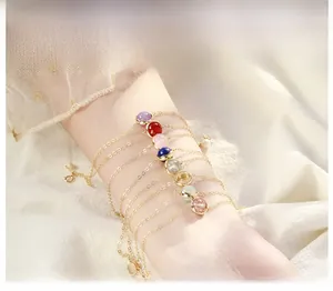 Detail of colorful gemstone beaded bracelet with gold chain and pearl charm on a wrist