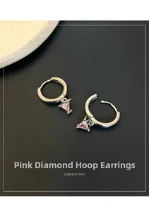 Detailed macro view of S925 silver stamp and pink triangular zircon on hoop earrings