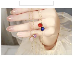 Detail of colorful gemstone bracelets with gold chains and bezel setting stones