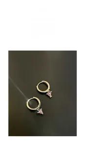 Macro shot of silver ring earrings featuring a pink triangle gemstone pendant