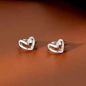 Minimalist hollow heart hoop earrings in 925 sterling silver on brown leather