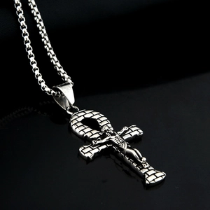 Dettaglio del ciondolo a croce Ankh d'argento con figura di Gesù su specchio nero