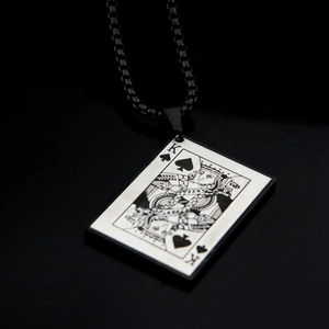 Macro detail of King of Spades pendant with a black box chain and engraved metal texture