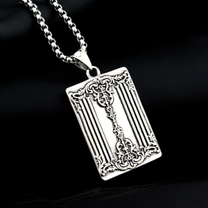 Macro shot of vintage silver steel poker K necklace pendant with baroque floral patterns