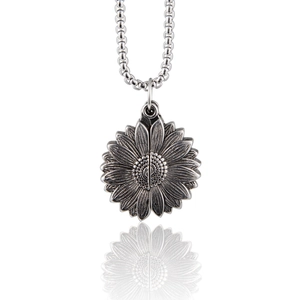 Vue détaillée du médaillon tournesol en argent vintage sur une chaîne à billes