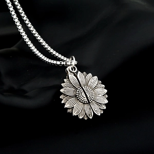 Pendentif tournesol unisexe en acier inoxydable argenté sur fond de satin noir