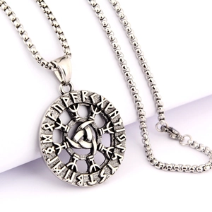 Macro shot of vintage silver Viking Odin pendant with Rune runes and Nordic geometric patterns