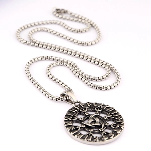 Macro detail of Viking Odin Triskele pendant with Nordic runes on box chain