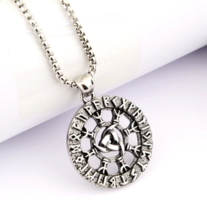 Macro detail of silver Viking Odin runes pendant necklace with Triskele symbol