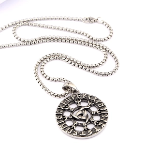 Detailed macro shot of vintage silver Viking Odin pendant with Celtic knot and rune engravings
