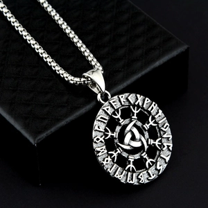 Close-up of vintage Viking Valknut pendant with Rune letters on a black textured box