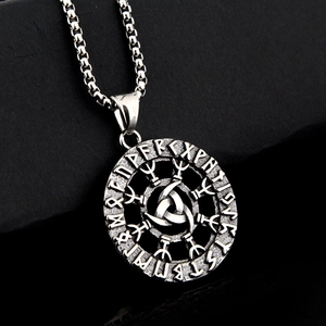 Close-up of vintage Viking pendant with Nordic runes and Celtic knot on black background