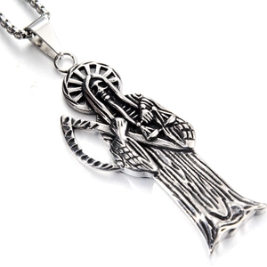 Détail macro du pendentif Santa Muerte avec faux et balance sur chaîne en acier