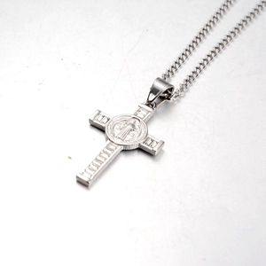 Macro detail of silver St. Benedict cross pendant with polished stainless steel finish