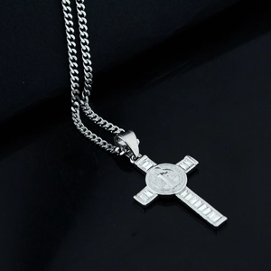 Detailed view of silver St. Benedict cross pendant with rectangle zircons and Cuban chain