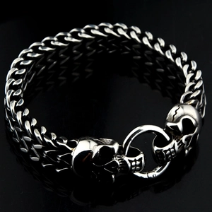 Gros plan sur le bracelet à gourmettes multicouches avec fermoir à double tête de mort