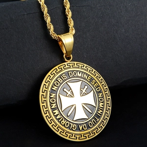 Detalle macro del colgante de escudo dorado con relieve de cruz y grabado en latín