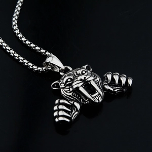 Détail macro du pendentif tête de tigre argenté avec griffes sur chaîne box