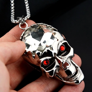 Détail d'un grand pendentif tête de mort avec gemme frontale et yeux en strass rouges