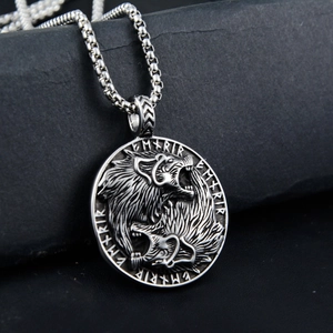 Detailed close-up of a Viking double wolf head pendant with Nordic runes on a stone background