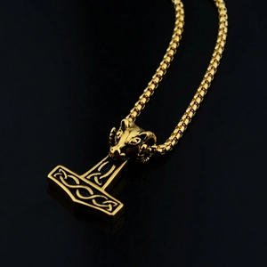 Detail of Thor's hammer Mjolnir pendant with ram head carving and celtic knot patterns