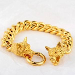 Détail du bracelet gourmette doré avec fermoir design à double tête de loup sculptée