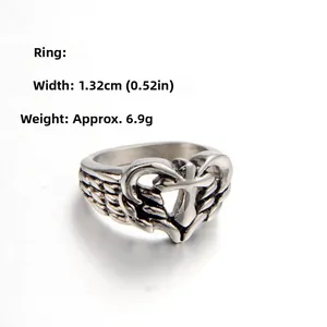 Macro detail of vintage heart and cross ring with wing textures in antique silver
